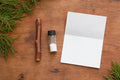 Redwood tree cutting rooting kit flat-lay: a bare leafless redwood cutting, a small vial of rooting powder and an instruction sheet on a wooden table
