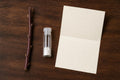 Plum tree cutting rooting kit flat-lay: a bare leafless plum cutting, a small vial of rooting powder and an instruction sheet on a wooden table