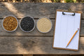 Kit contents: three clear dishes with dried mealworms, sunflower seeds and millet beside a clipboard tally sheet